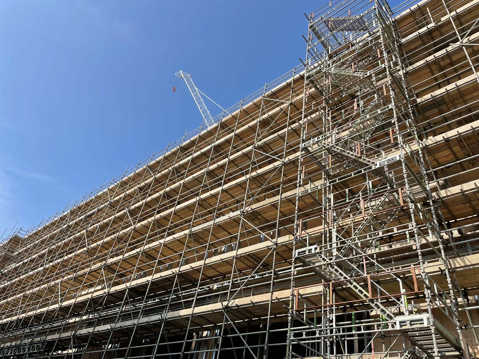 Ponteggio metallico su una facciata in costruzione, ripreso dal basso